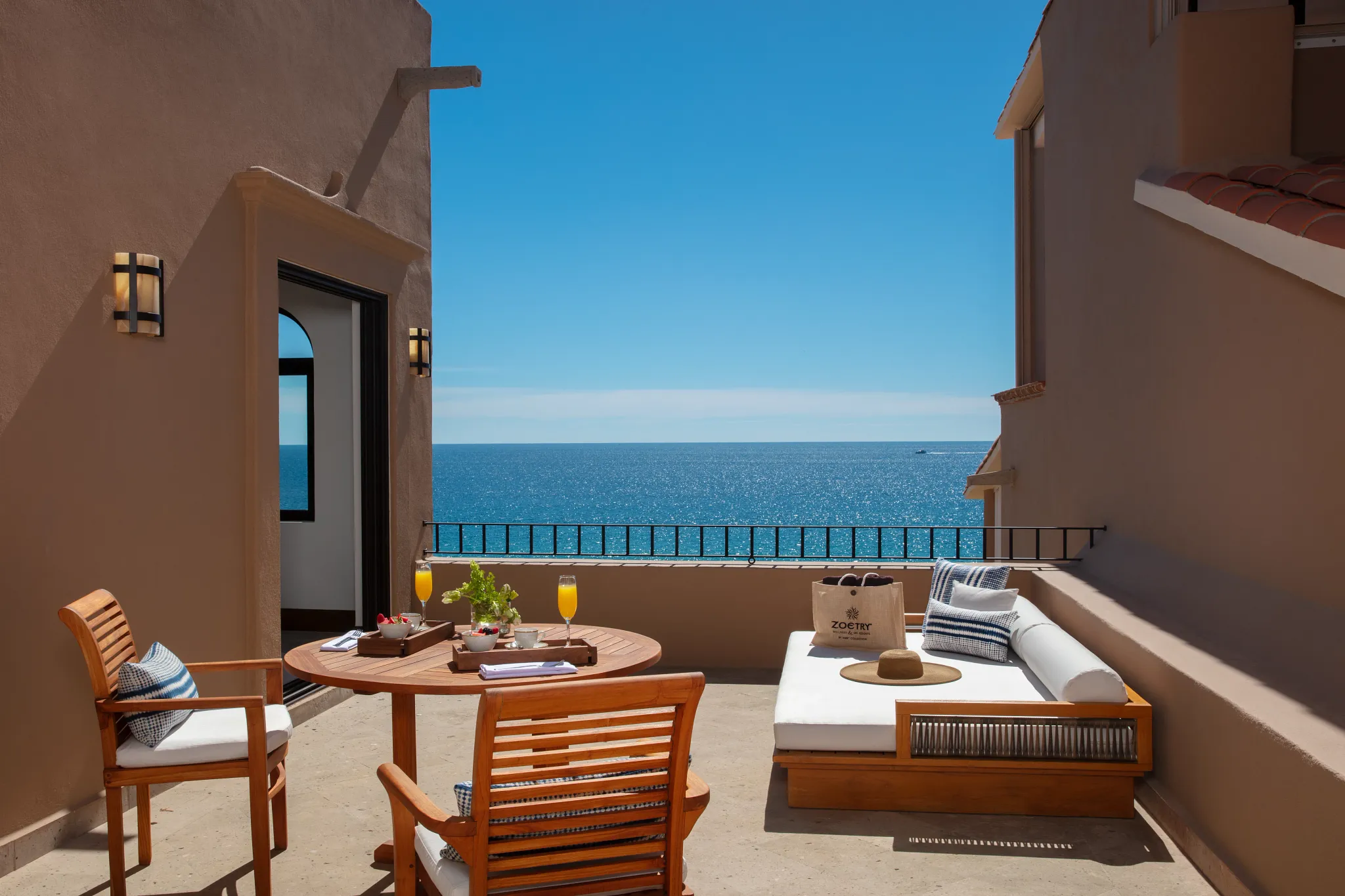 One Bedroom Suite oceanfront terrace with lounge seating and panoramic sea views at Zoëtry Casa del Mar Los Cabos.